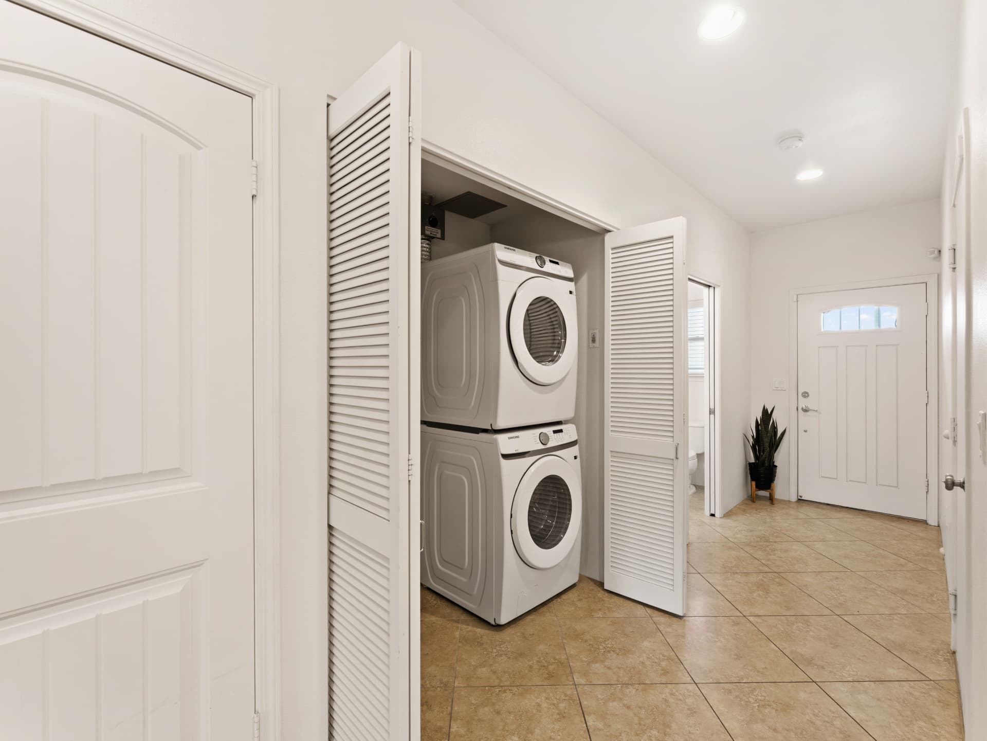 Full-size stacked washer and dryer closet near the entry