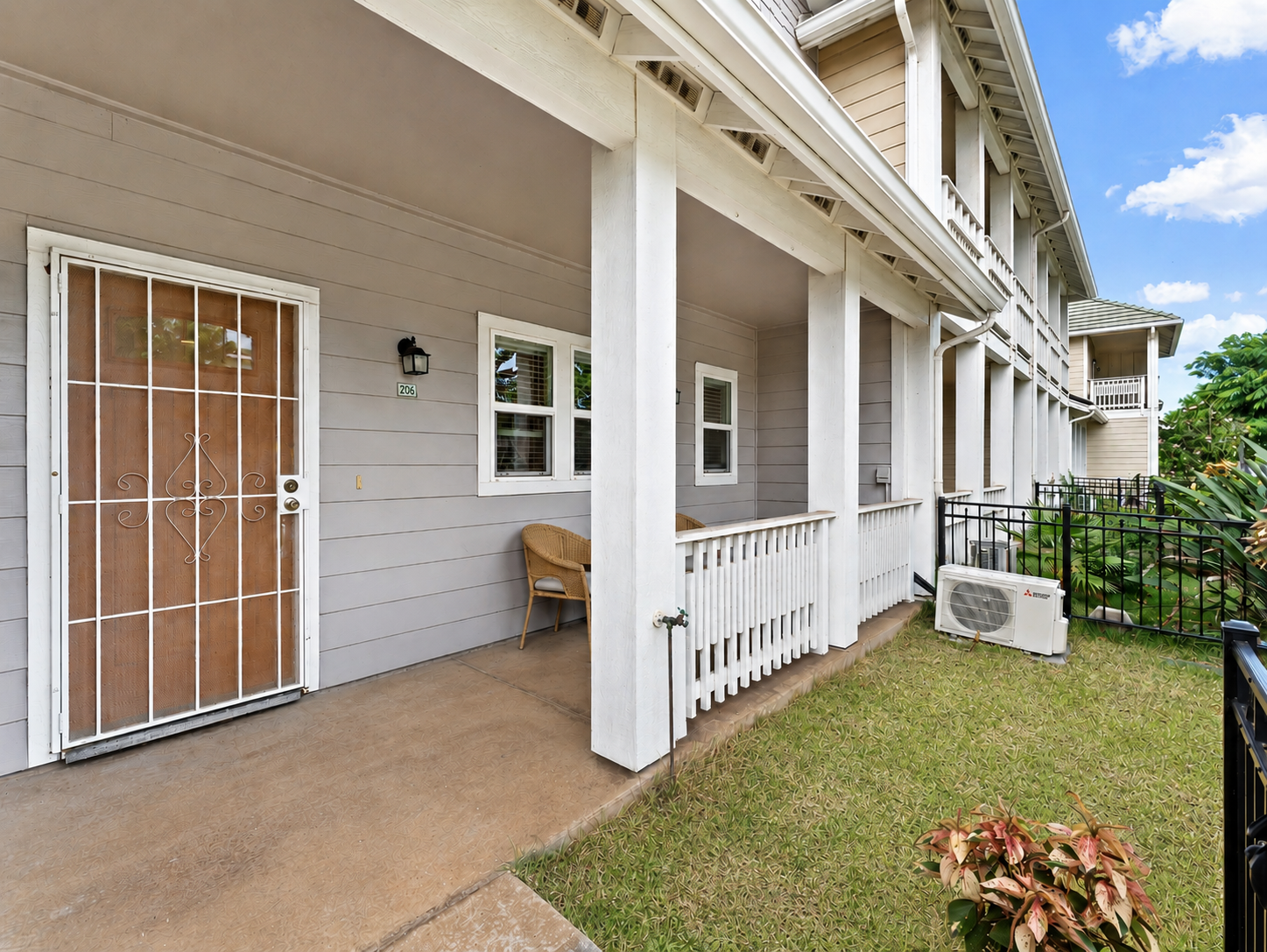 Front entry to unit 206 with covered porch and split A/C unit