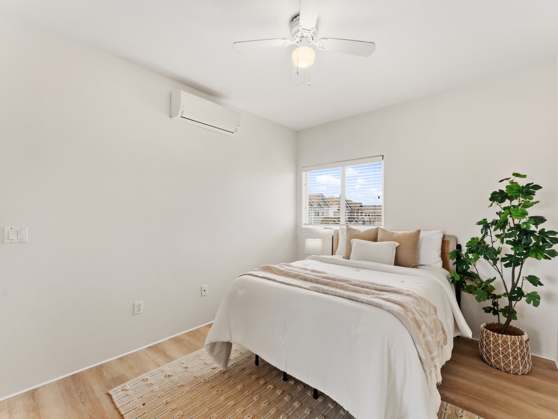 Bedroom with split A/C, ceiling fan and neighborhood view