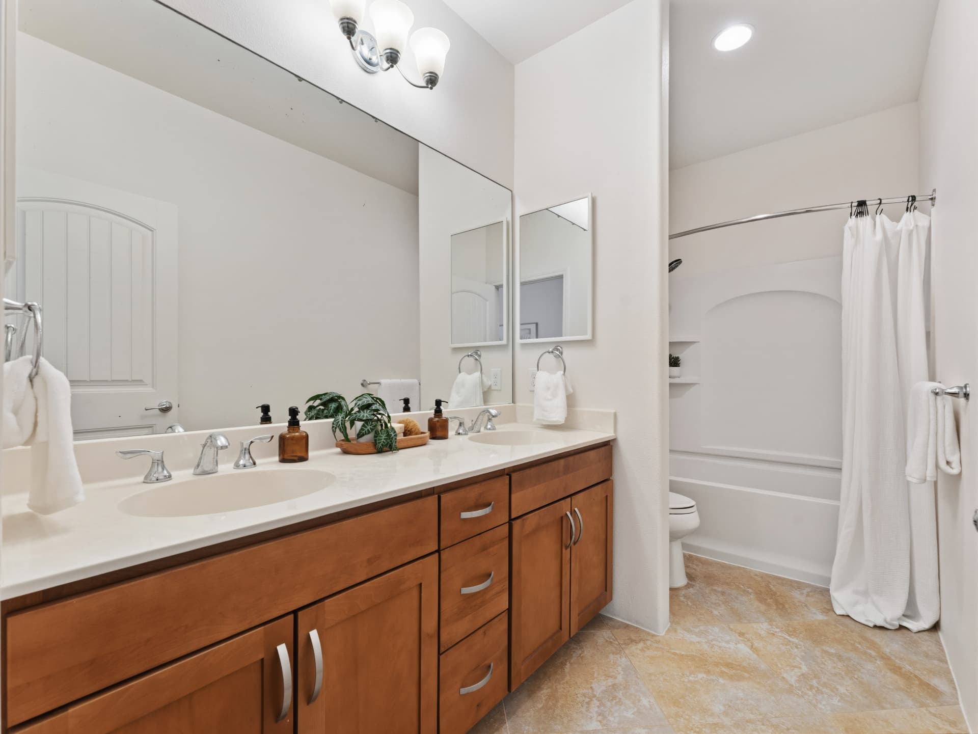 Primary bathroom with double vanity and tub-shower combo