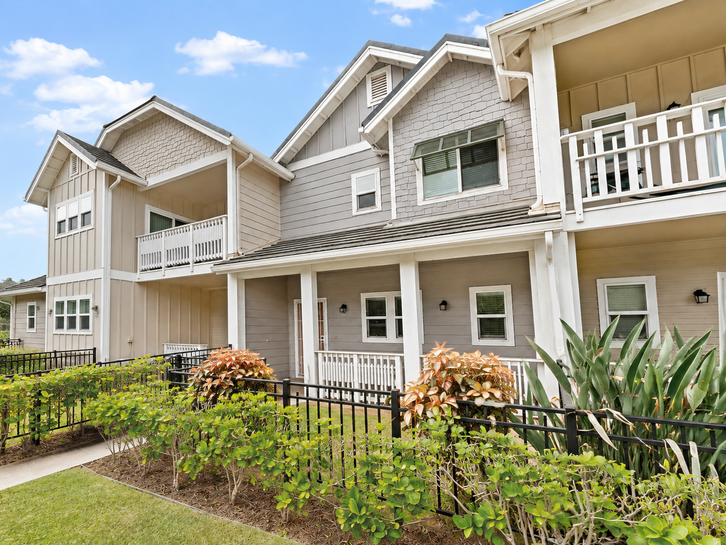 Side view of the townhome building with balconies and tropical landscaping