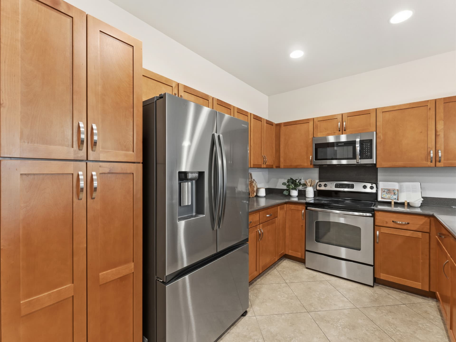 Kitchen with full-height pantry cabinets and stainless refrigerator