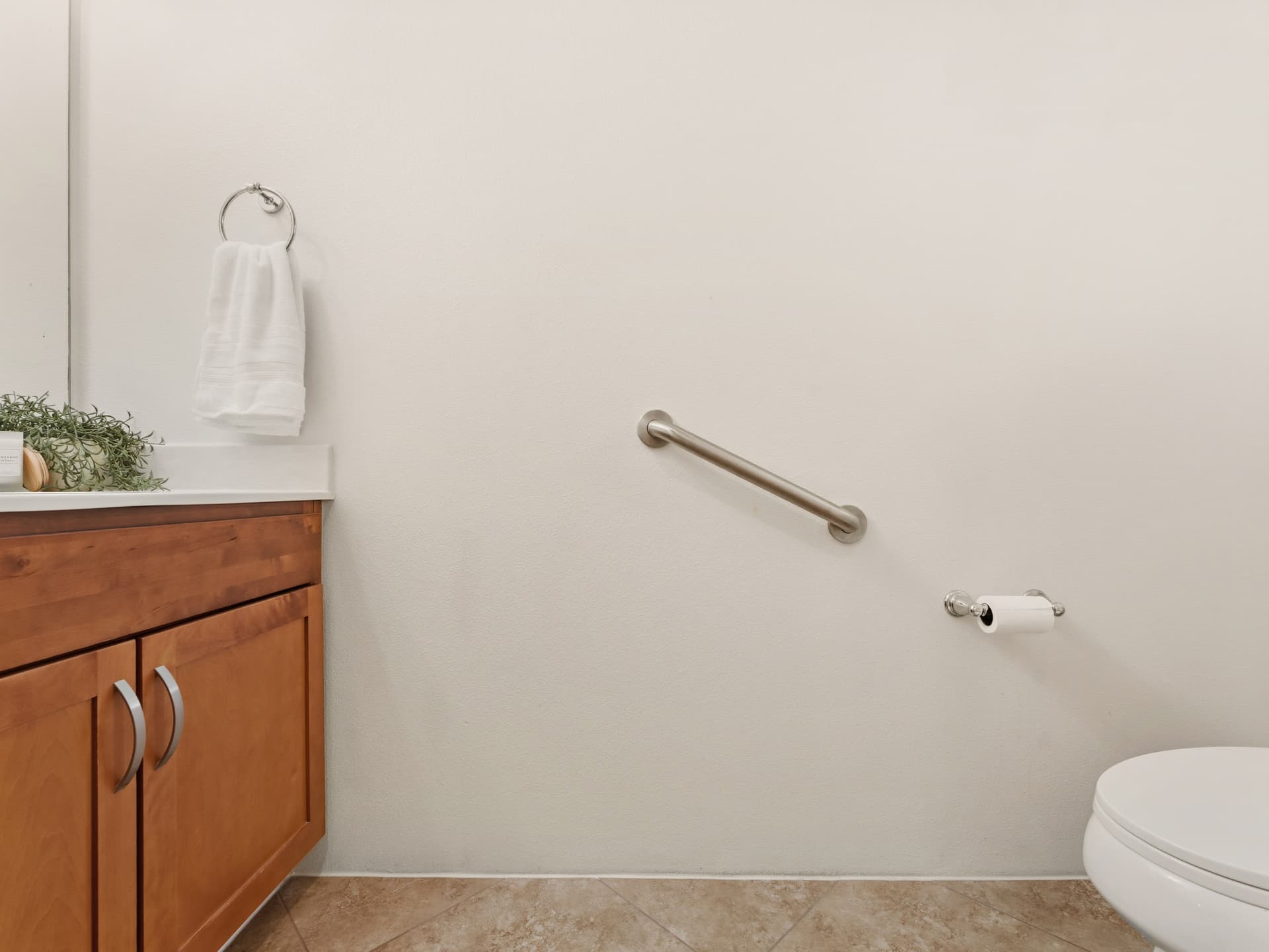 Half bathroom with vanity, grab bar and toilet