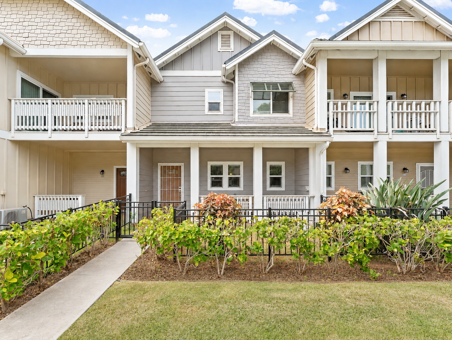 Front elevation of the craftsman-style townhome with covered lanai and manicured lawn