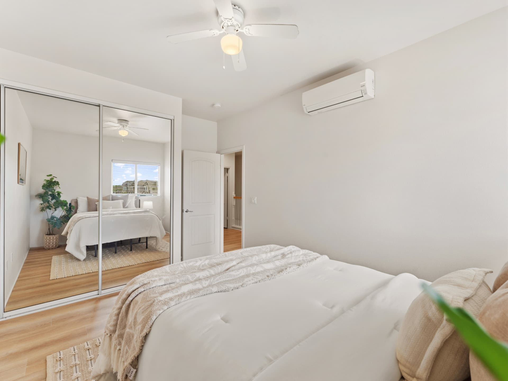 Bedroom with mirrored closet doors and ceiling fan